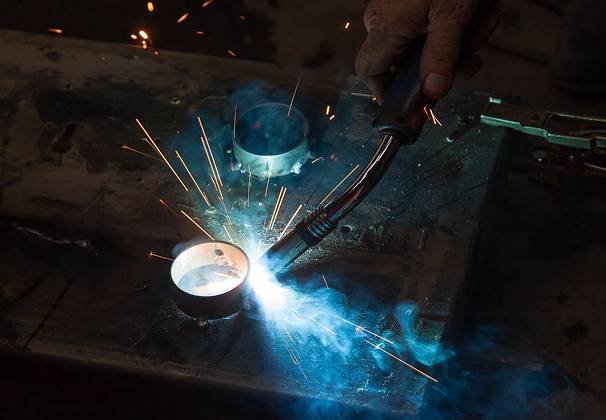 Osoba spawająca kawałek metalu.